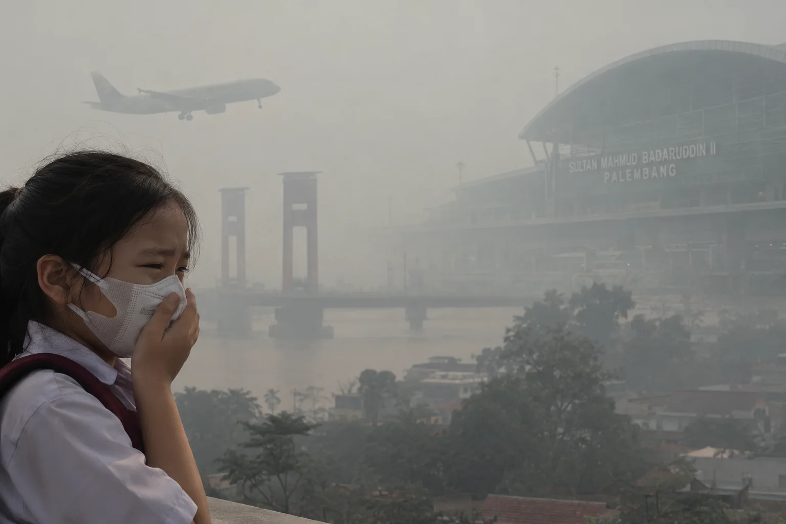 Smoggy Palembang Airport Scene with Masked Student